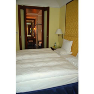 Blick-ueber-das-doppelbett-hinweg-ins-badezimmer